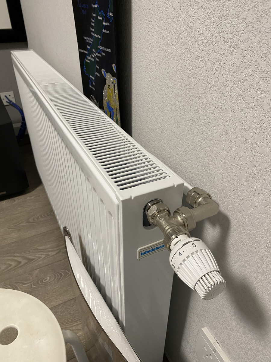 本類明裝工程的現場照片：生活陽臺上的燃氣壁掛爐與向上出戶的排煙管